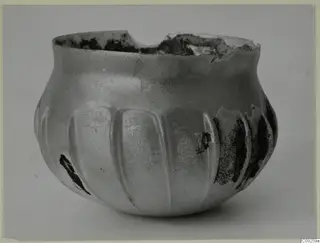 Blown glass vessel with vertical ribs and a broken, uneven rim