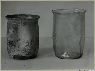 Two blown glass beakers standing side by side on a plain surface.