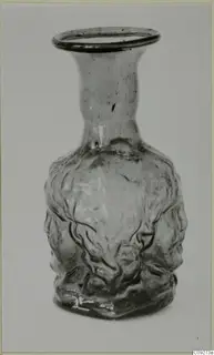 Blown glass vessel with a flared neck and moulded faces on its body
