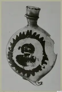 Blown glass flask with a dark sawtooth-rimmed roundel painted on its body