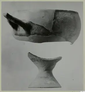 Two pottery objects: a broken vessel with a spout-like projection above, and a pedestal-shaped piece below.