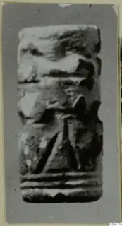 Cylinder seal from Ayios Iakovos, photographed upright, with carved bands and a central motif.