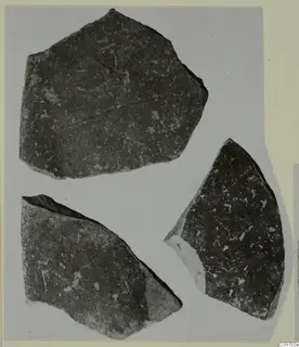 Three Levanto-Helladic pottery sherds with dark speckled surfaces, laid out on a grey card