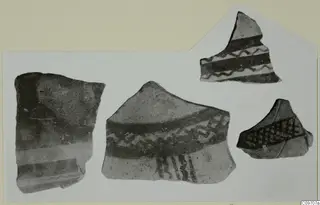 Four pottery sherds with dark painted bands, wavy lines and cross-hatching, shown together on a card