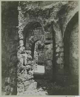 Interior of a ruined stone structure in the Kyrenia Mountains, with arched openings and rubble on the floor