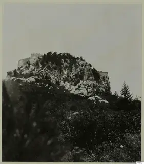 Rocky hill in the Kyrenia Mountains, with ruined stone walls along its summit, trees and shrubs below.