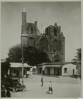 Stone façade of the Lala Mustafa Pasha Mosque, Famagusta, with a slender minaret, seen across an open square