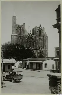 Saint Nicholas cathedral in Famagusta, seen across a street with a small open truck in the foreground