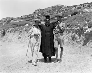 Erik Sjöqvist, Papa Polivios and Einar Gjerstad standing arm in arm on a dirt road in Mandres