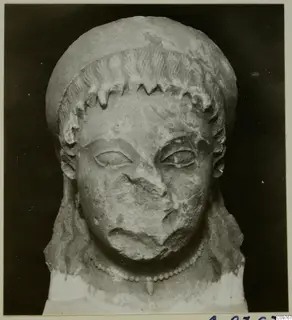 Limestone head from Arsos, frontal view, with the nose and mouth broken