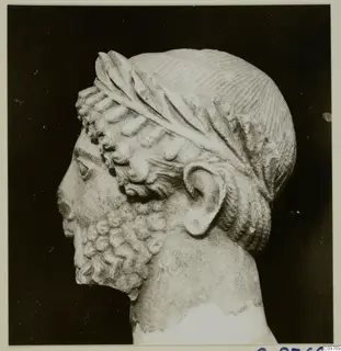Sculpted stone head of a bearded man in left profile, from Arsos, with a leaf band in the hair.