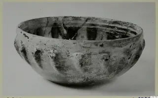 Rounded bowl with a thick rim and grooved lower body, shown on a plain grey background