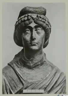 Roman sculpture of a woman's head and upper torso in stone, Vienna, with a curled hairstyle and draped garment