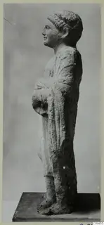 Limestone statue of a standing figure in profile, with a draped cloak, from Mersinaki