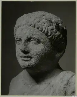 Limestone head and upper body of a young figure with short curled hair, from Mersinaki