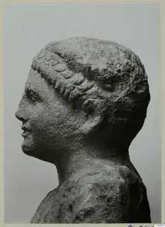 Head and shoulders of a sculpted figure in profile, facing left, with wavy hair bands across the forehead.
