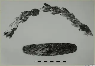 Two pieces of jewellery made of metal leaves: an arched leaf wreath above and an oval band of overlapping leaves below