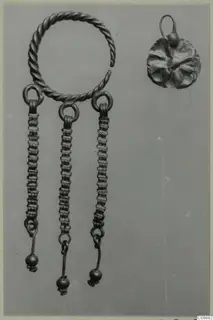 Earring with a twisted wire hoop, three beaded chains ending in small balls, and a disc pendant with loop.