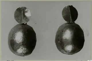 Two gold earrings, each with a round disc and a rounded lower bulb, shown side by side against a grey background.
