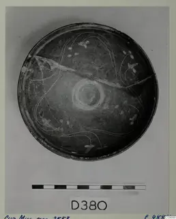 Cypro-Hell. II bowl seen from above, dark surface with thin white lines and small white dabs, cracked across