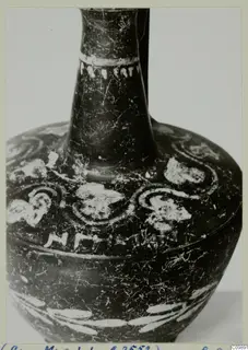 Dark-surfaced pottery bottle with a long narrow neck and white painted spiral and band decoration