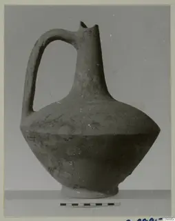 Pottery jug with a strap handle, broken rim and ring base, shown beside a scale bar