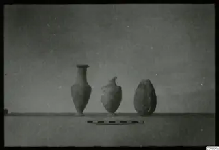 Three vessels on a ledge with a scale bar in front, from Ajii Omologitades, Politiko and Limassol Oasis