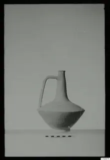Jug with a single loop handle and narrow neck, photographed beside a scale bar against a plain backdrop