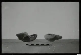 Two lamps, one broken, photographed side by side with a scale bar in front of them