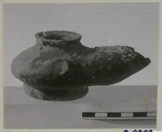 Pottery vessel with a wide top opening, a long pointed spout and a ring base, shown beside a scale bar