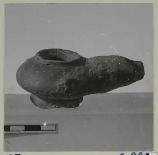 Vessel with a wide rim opening and a long tapering spout, photographed beside a scale bar