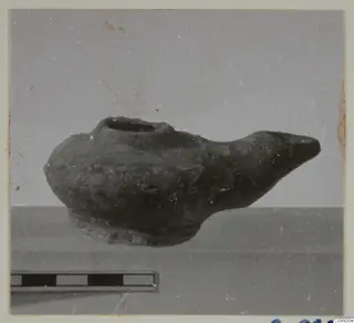 Oil lamp with a filling hole and long pointed nozzle, shown beside a scale bar.