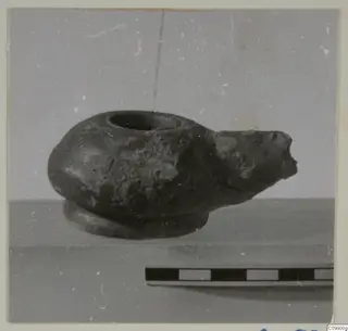 Dark vessel with a short spout and wide round opening, shown beside a scale bar