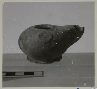 Pottery vessel with a filling hole and broken spout, shown beside a scale bar
