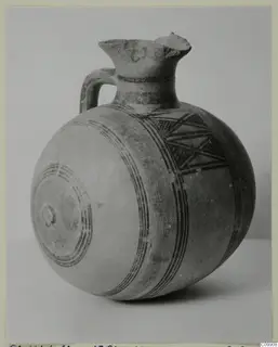 Pottery Bichrome II jug with a rounded body, flared neck, strap handle and dark painted bands
