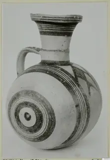 White Painted II jug with a flared neck, loop handle and dark concentric circles on the body