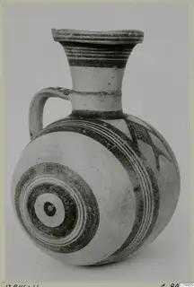 White Painted II jug with a flared rim, a strap handle and dark bands and concentric circles on a pale body