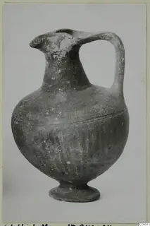 Black Slip I-VI pottery jug with a single handle, pinched spout and low ring base