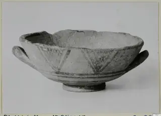 Pottery Bichrome II bowl with two side handles, painted dark bands and triangular hatching, shown on a plain background
