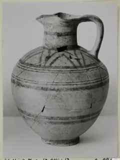 Pottery Bichrome II jug with a single handle and dark painted bands, photographed against a plain background