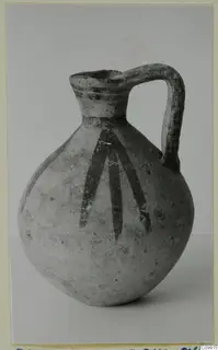 Pottery Bichrome V jug with a strap handle and dark painted strokes running down the body