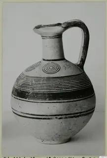White Painted IV jug with concentric circles and horizontal bands painted on a pale surface