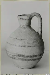 White Painted V jug with a single loop handle and dark painted bands, photographed against a plain background