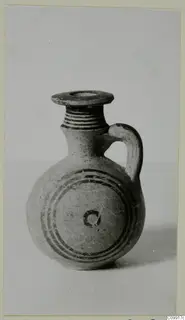 Jug with a ribbed neck, a single loop handle and dark concentric bands painted around its body