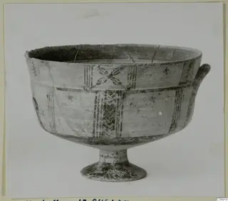 Footed bowl with a single handle, its outer wall painted with dark bands and motifs