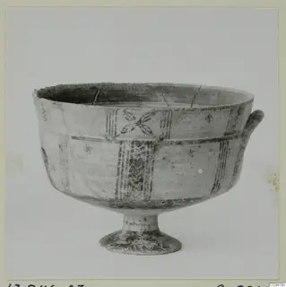 Footed bowl with a loop handle, painted horizontal bands, vertical panels and a cross-like motif