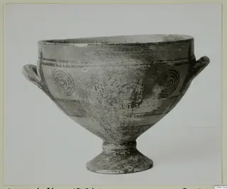 Footed bowl with two horizontal handles and concentric circle motifs painted on its body.