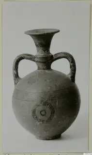 Two-handled vessel with a flaring neck, dark painted concentric circles and horizontal bands on its body