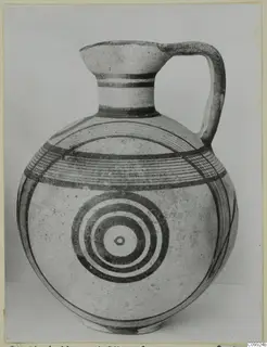 Pottery White Painted IV jug with a round body, tall neck and strap handle, decorated with concentric circles and bands.