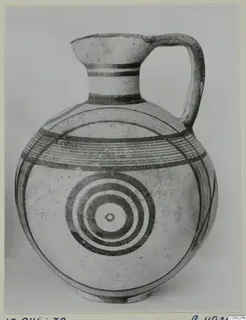 Pottery White Painted IV jug with a high loop handle and concentric circles painted on its round body